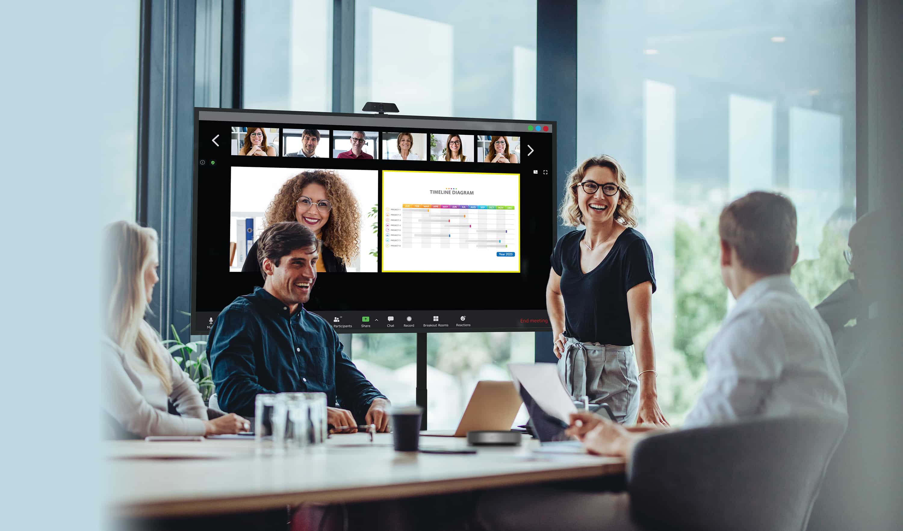 Partnerzy biznesowi prowadzący spotkanie z niektórymi pracownikami fizycznie obecnymi i patrzącymi na monitor Optoma serii N, podczas gdy ich zdalni koledzy są pokazywani na ekranie wraz z treściami, które udostępniają.